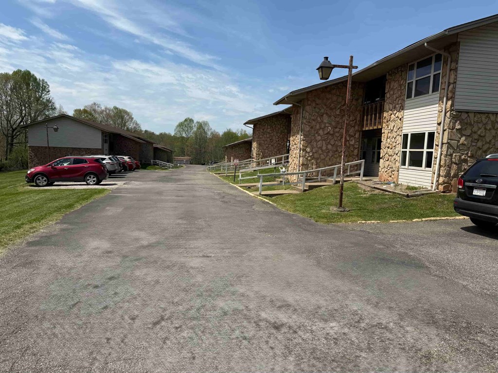 A parking lot with cars and a building in the background.