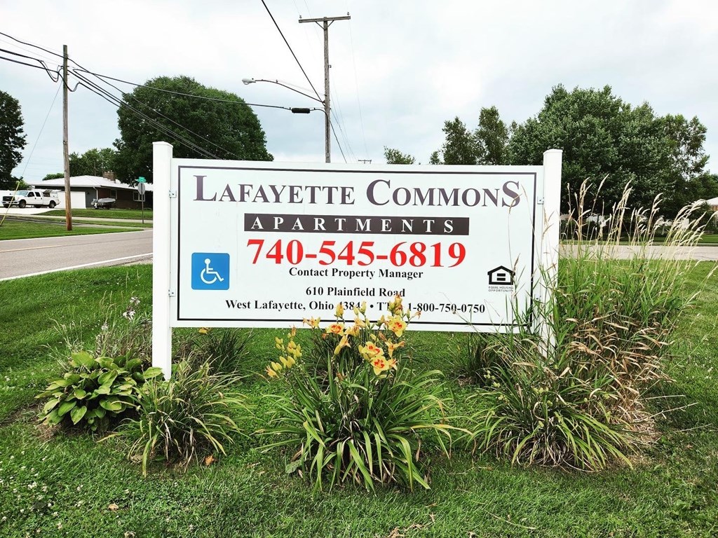 A sign for Lafayette Commons Apartments with a phone number and address.