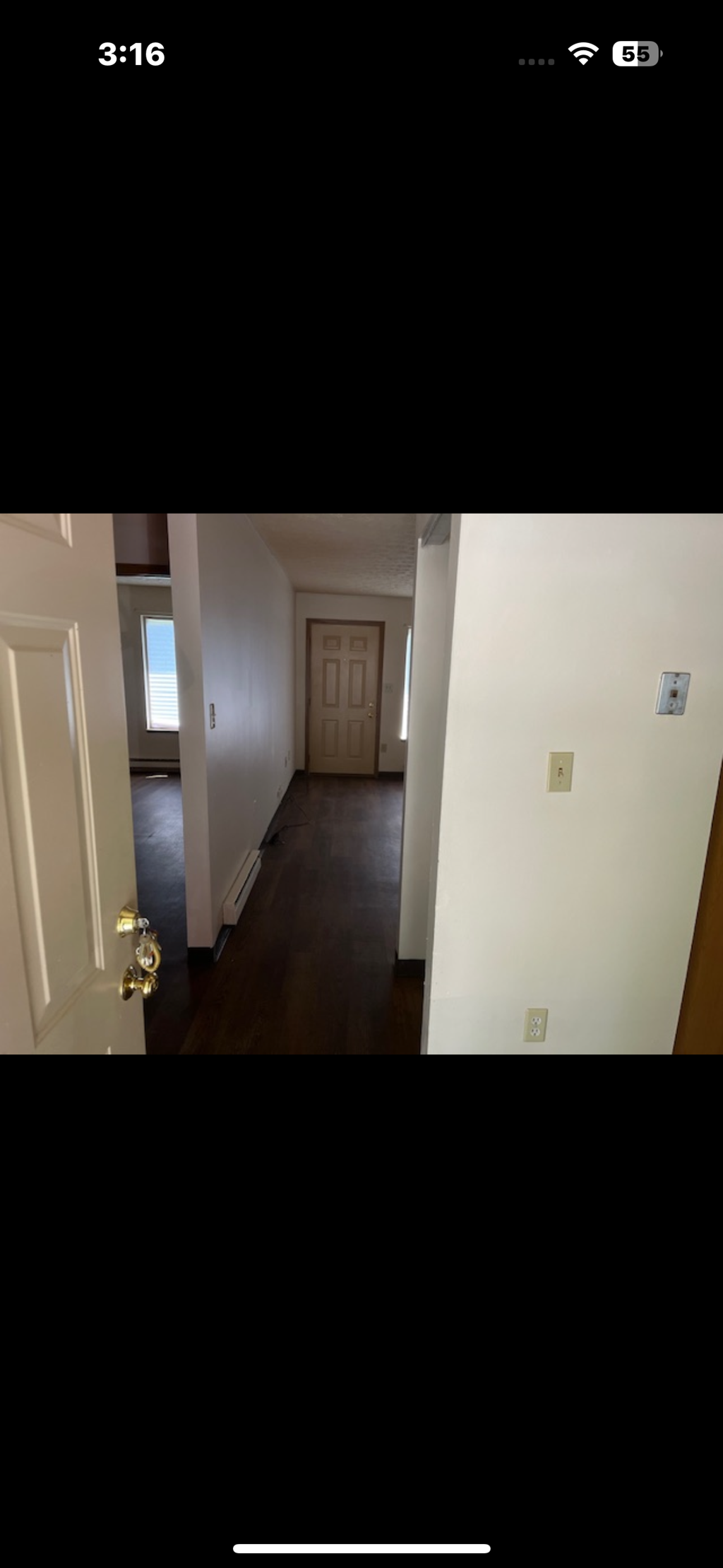 A long hallway with a door at the end.