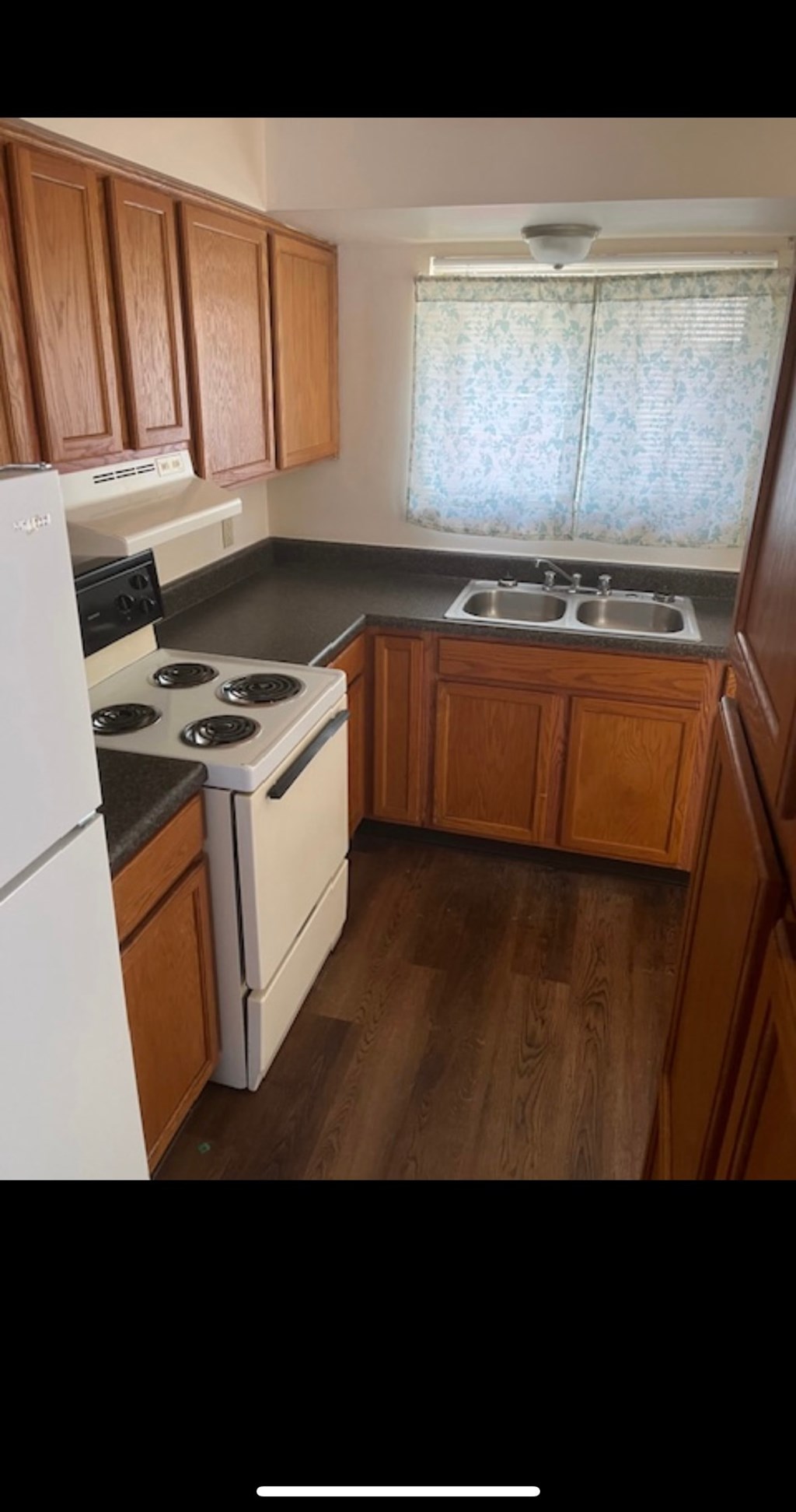 A kitchen with wooden cabinets and a white refrigerator.