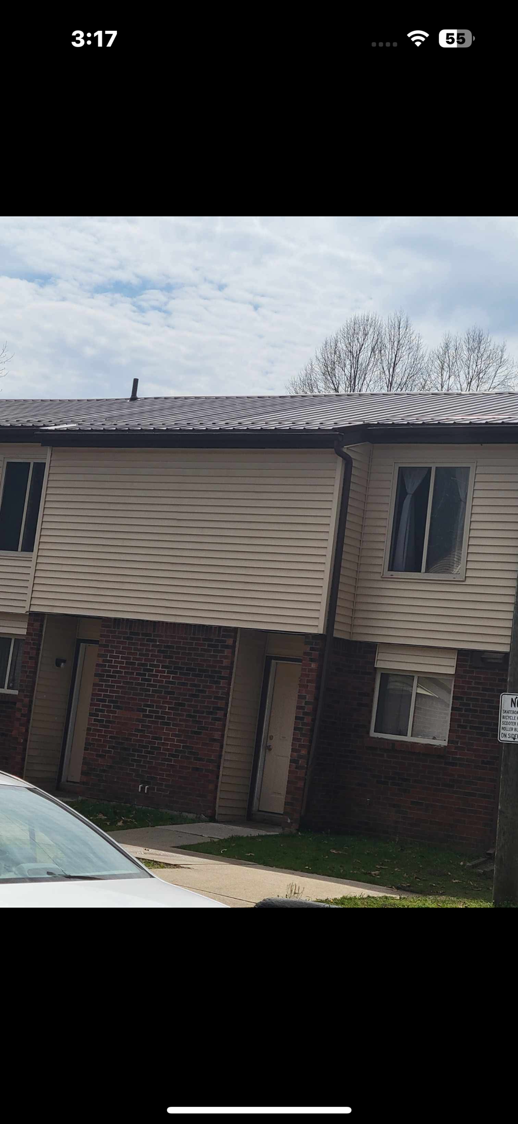 A building with a beige siding and a brown roof.