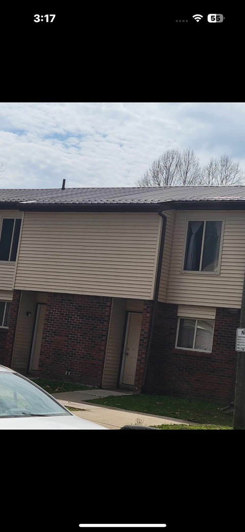 A building with a beige siding and a brown roof.