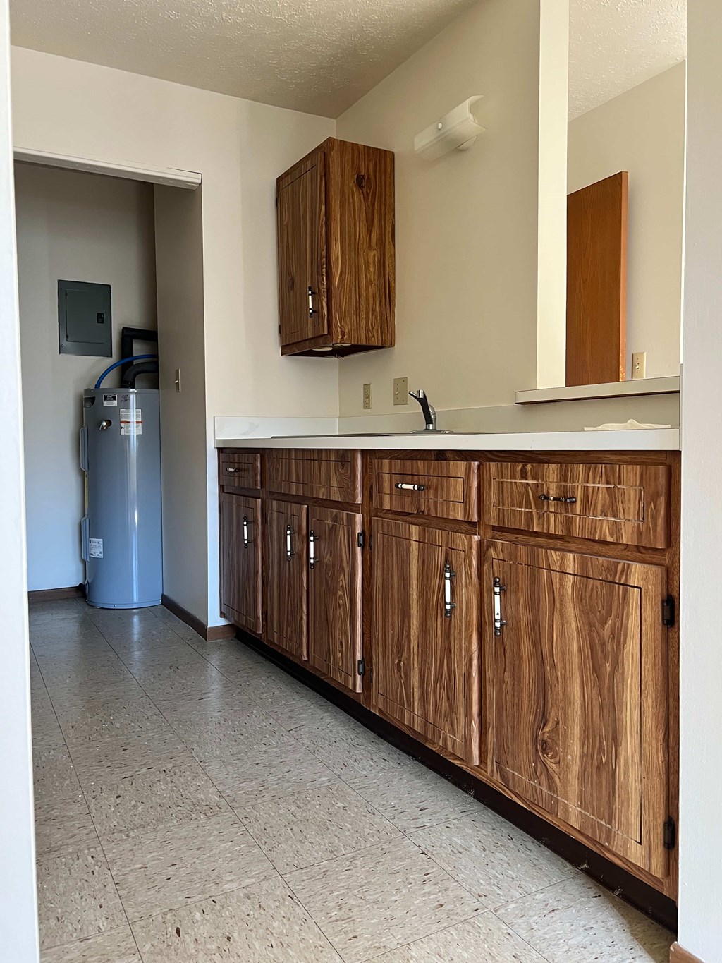 A kitchen with wooden cabinets and a white counter.