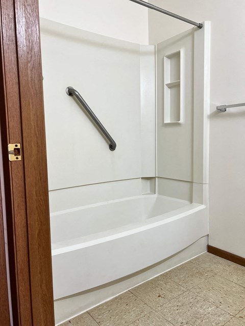 A white bathroom with a walk-in shower and a door.
