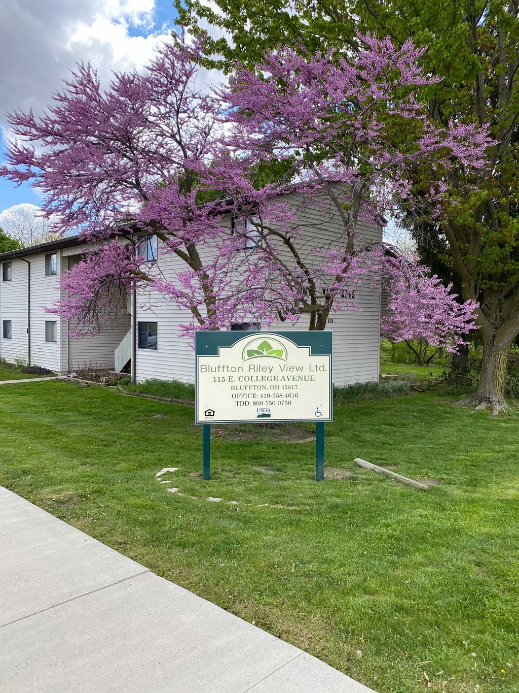A sign for Bluffton Riverview Lodge stands in front of a building.
