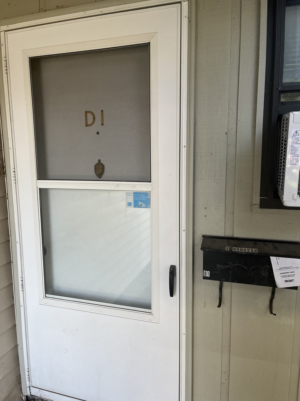 A white door with a glass window and a letter "D" written on it.