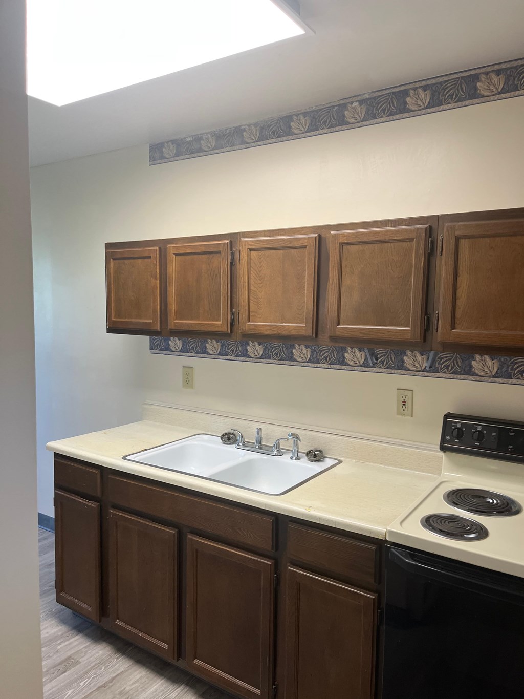 A kitchen with brown cabinets and a white counter top.
