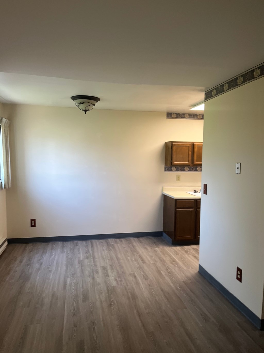 A room with a wooden floor and a brown cabinet.