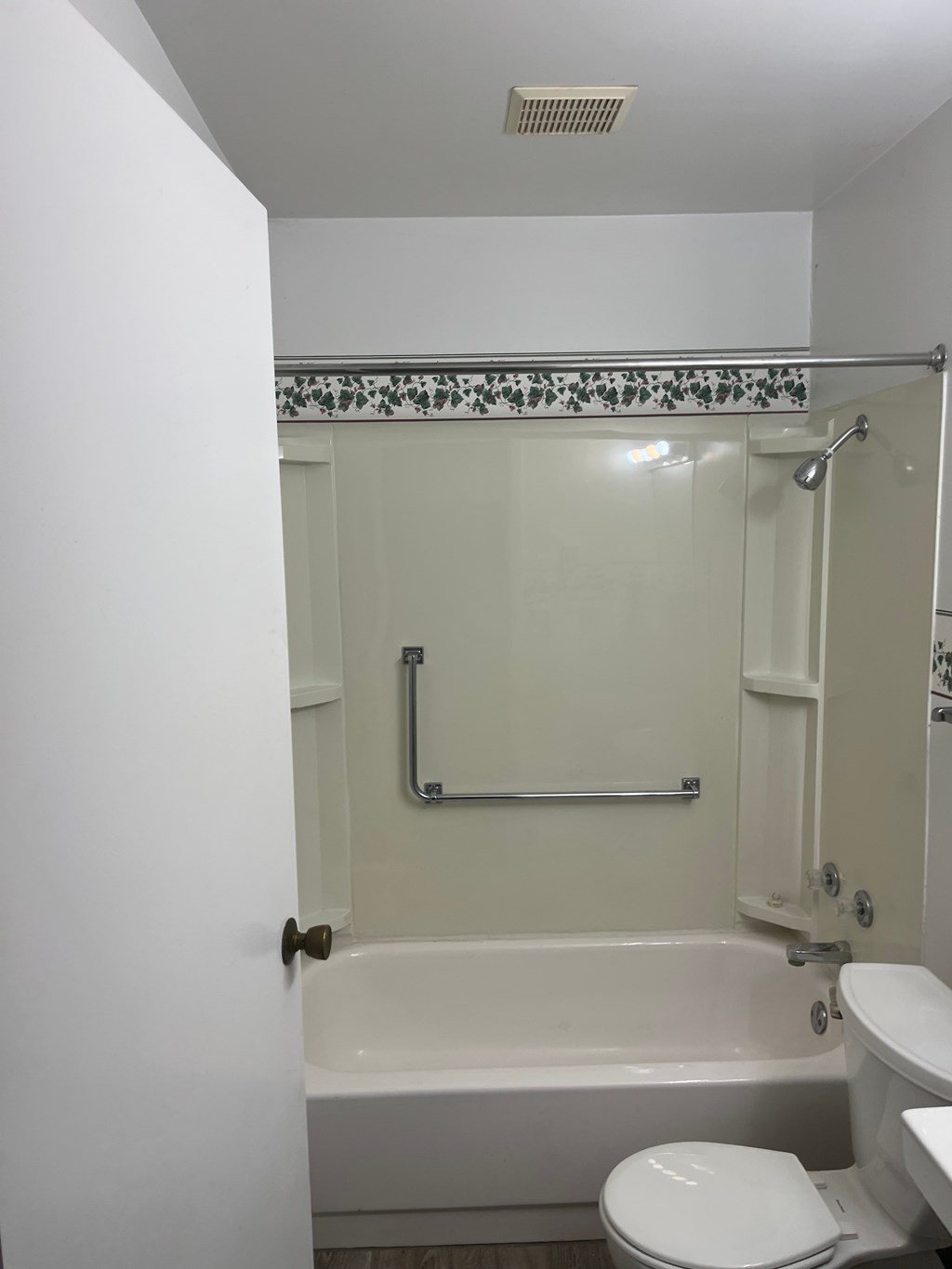 A white toilet sits next to a bathtub in a bathroom.