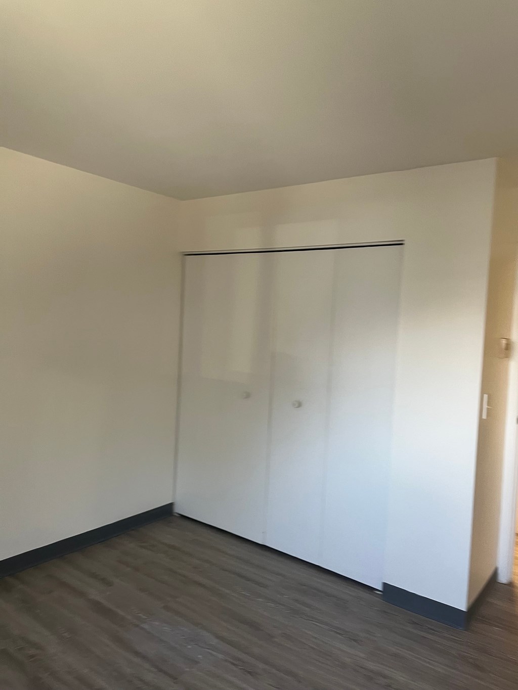 A room with a white wall and a glass door.