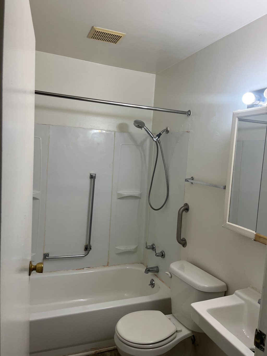 A white bathroom with a toilet, sink, and bathtub.