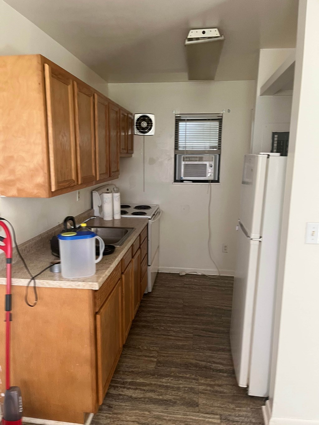 A kitchen with wooden cabinets and a white refrigerator.