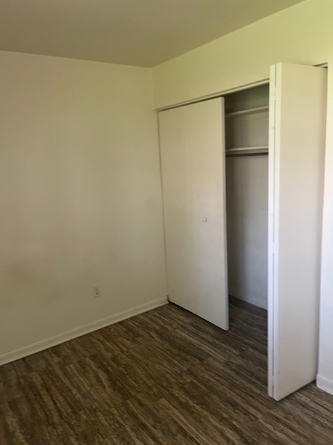 A room with a white door and a brown floor.