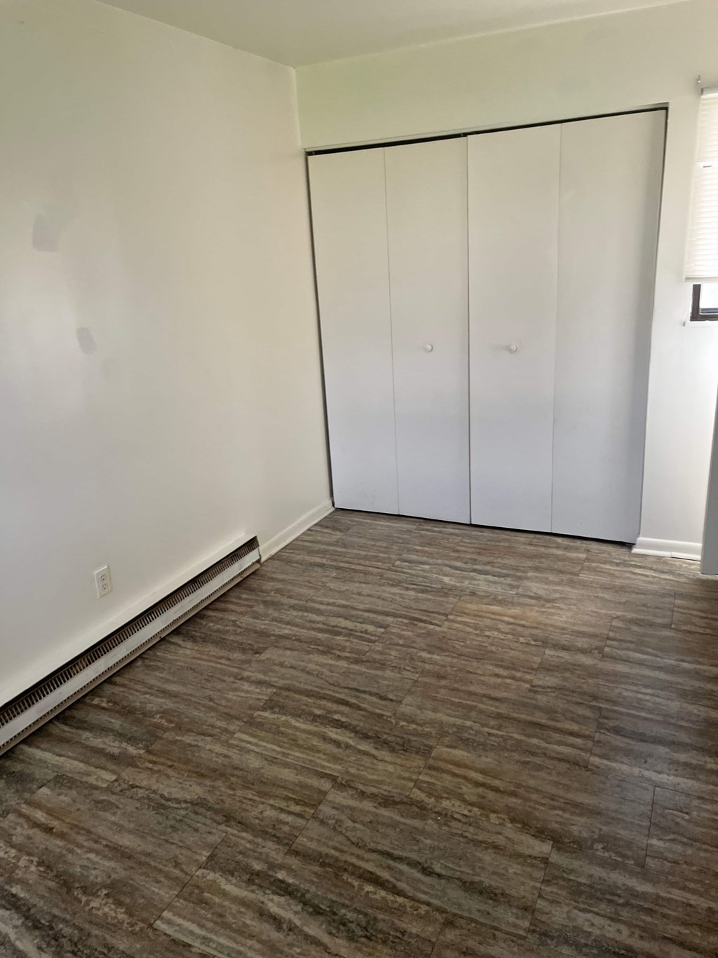 A room with a brown floor and white walls.