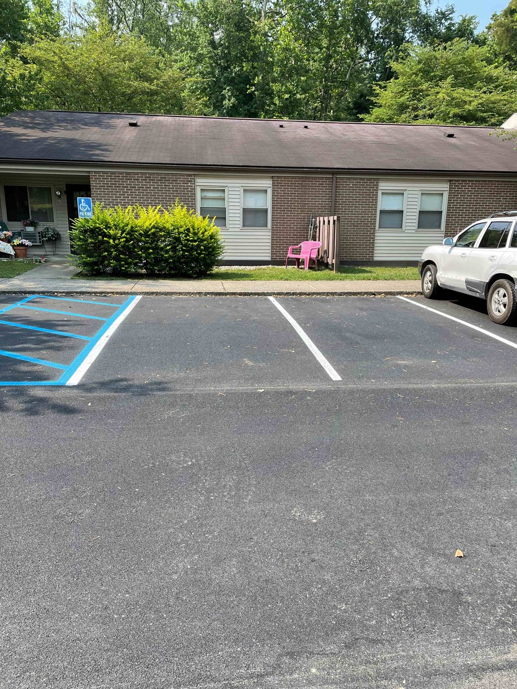 A parking lot with a white car and a blue painted area.