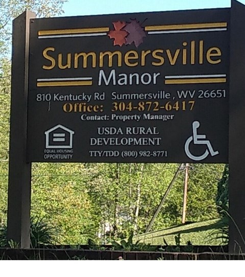A sign for Summersville Manor with contact information and logos.
