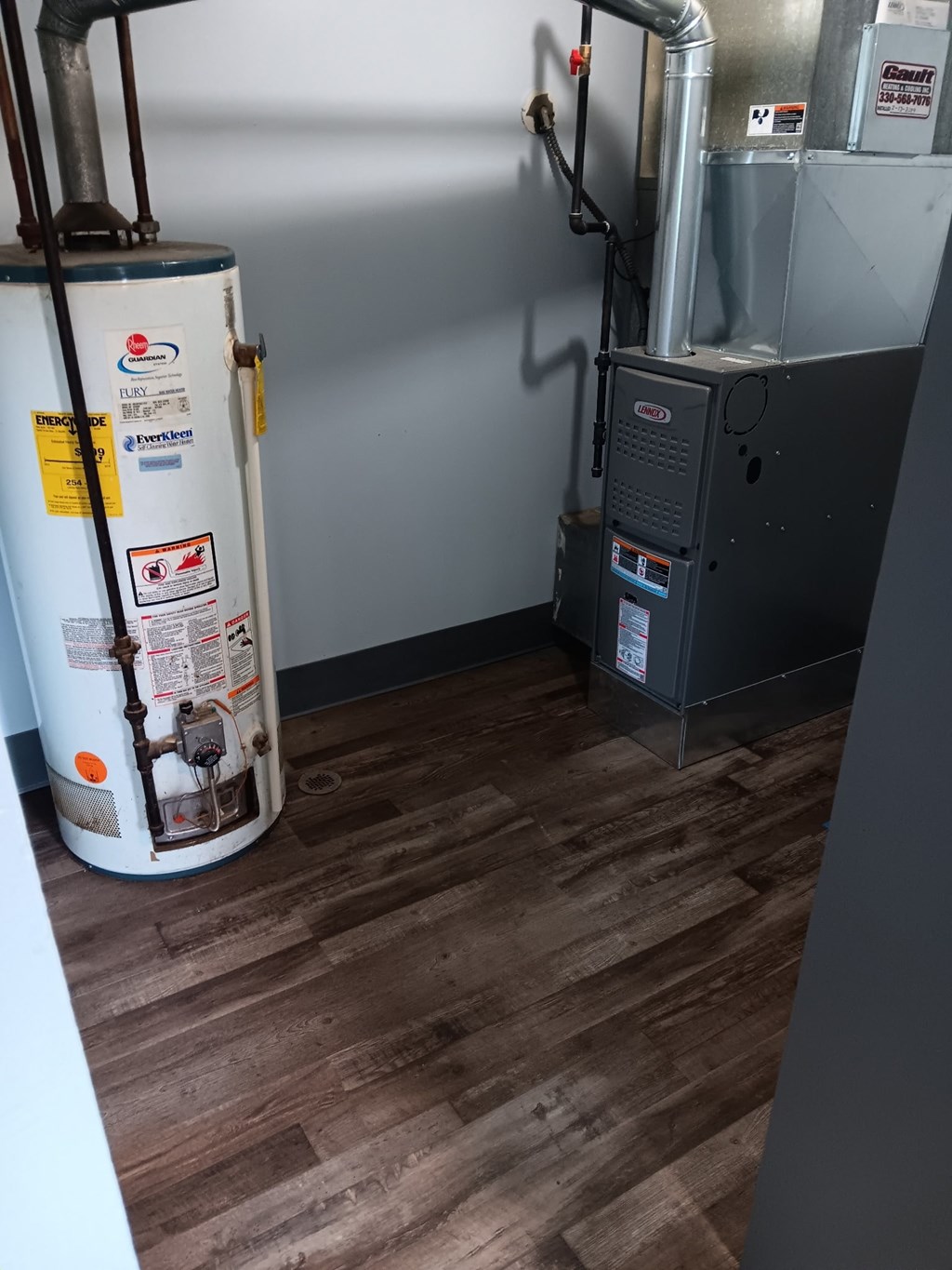 A room with a white wall and a floor with wooden planks.