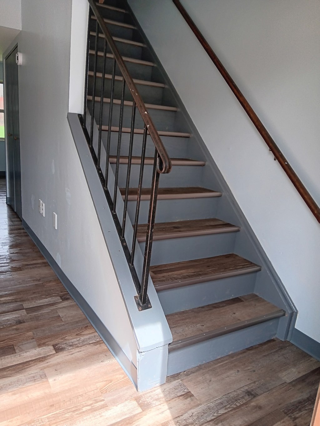 A staircase with wooden steps and metal handrails.