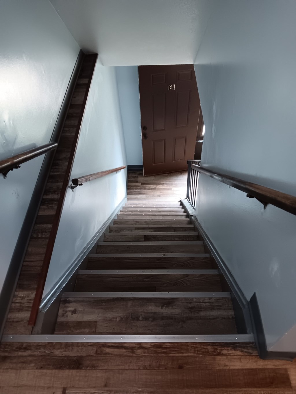A staircase with a railing on the left and right side.