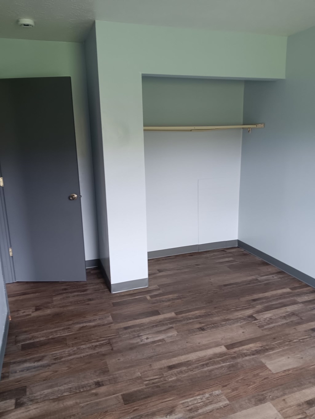 A room with a grey door and a white cabinet.