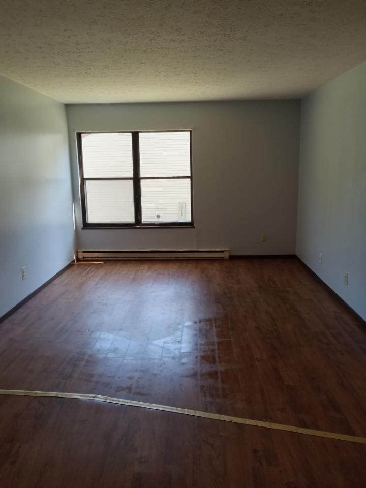 A room with a window and wooden floors.