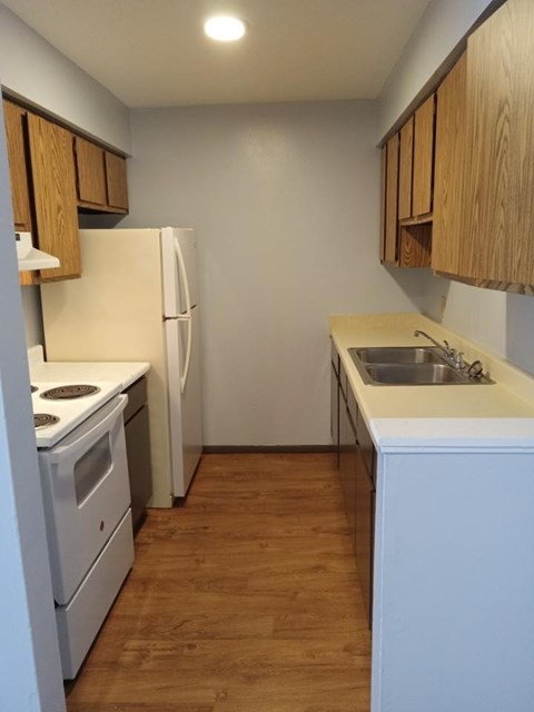 A kitchen with wooden cabinets and white appliances.