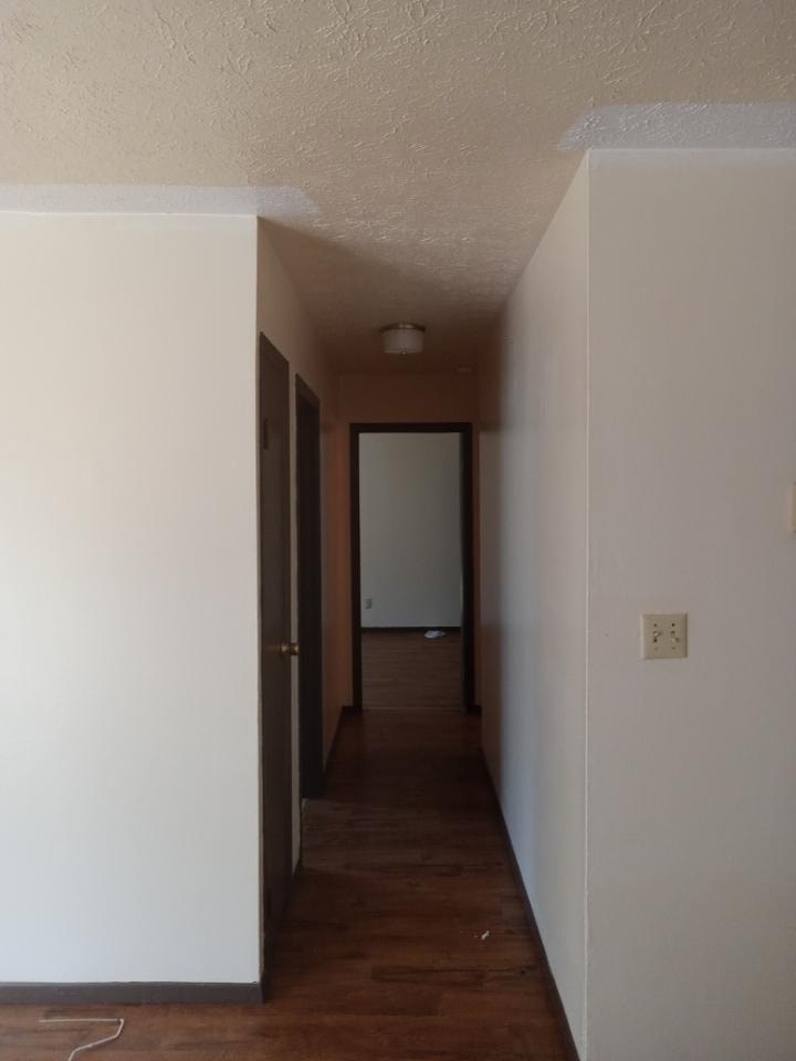A long, narrow hallway with a door at the end.