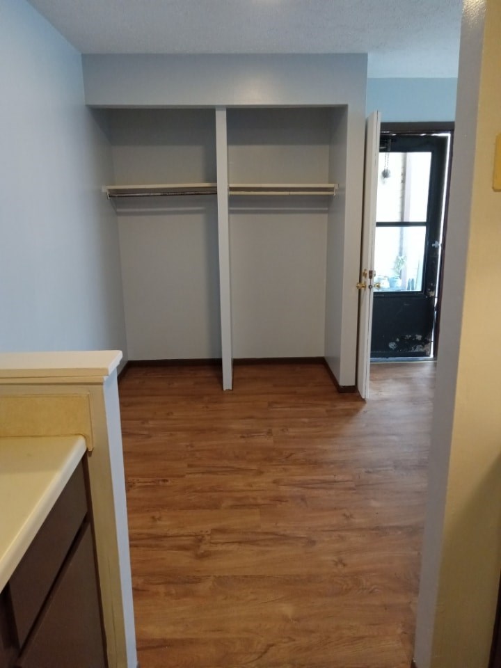 A room with a white door and a wooden floor.