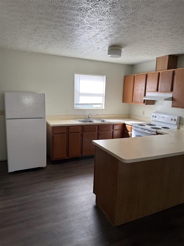 A kitchen with a white refrigerator and wooden cabinets.