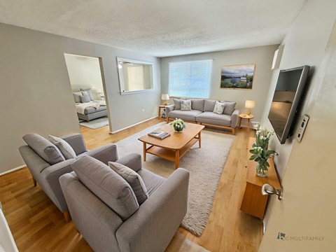 A living room with grey couches and a wooden coffee table.