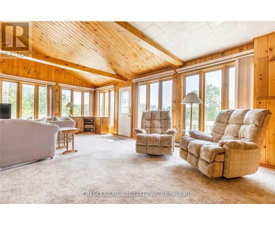 A living room with a couch, chairs and a television.