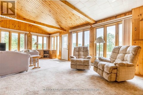 A living room with a couch, chairs and a television.