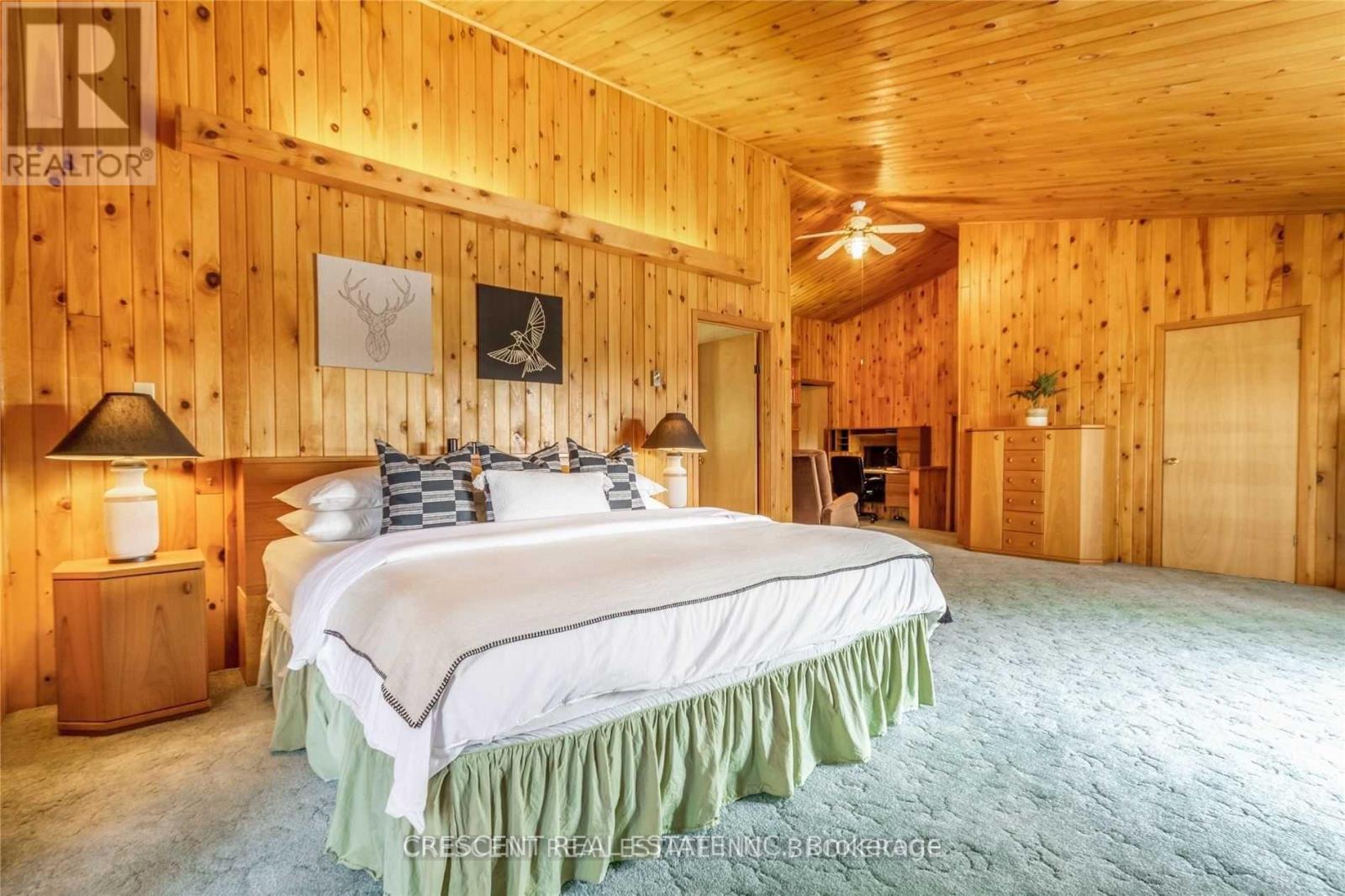 A bedroom with a large bed and wooden walls.