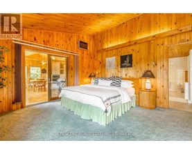 A bedroom with a large bed and wooden walls.