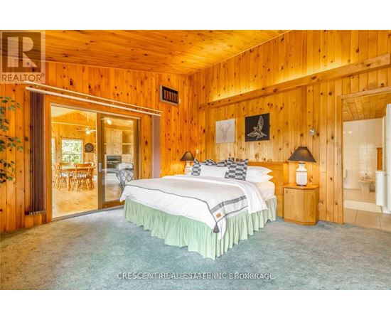 A bedroom with a large bed and wooden walls.
