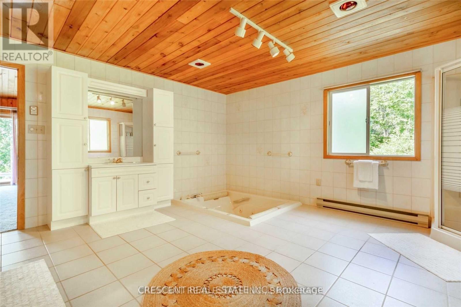 A well-lit, spacious room with wooden ceiling and white walls.