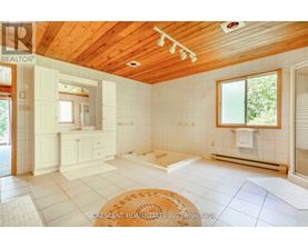 A well-lit, spacious room with wooden ceiling and white walls.