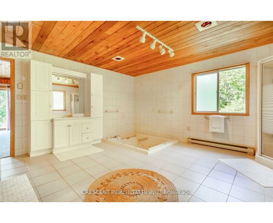 A well-lit, spacious room with wooden ceiling and white walls.