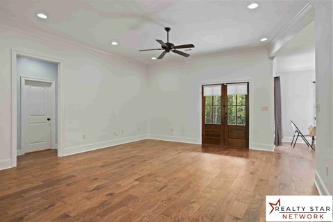 A room with wooden floors and a ceiling fan.