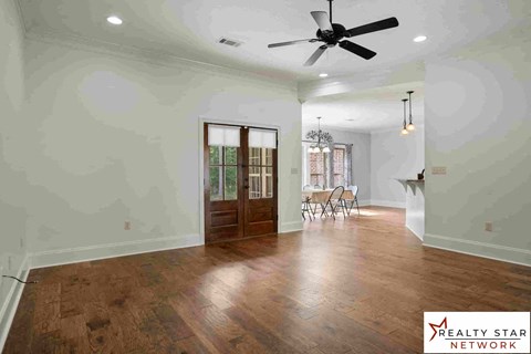 A room with wooden floors and a ceiling fan.