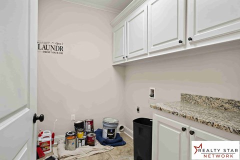 A laundry sign is on the wall in a room with cabinets and a counter.