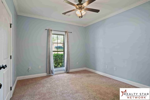 A room with a ceiling fan and a door leading outside.