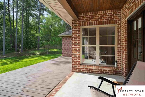 A wooden deck with a bench and a window is shown.