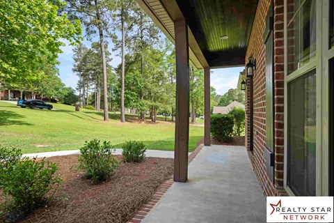 A porch of a house with a Realty Star Network logo.