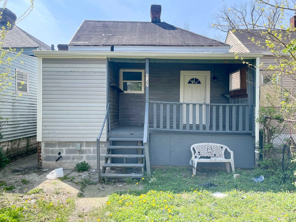 A small house with a white door and a porch.