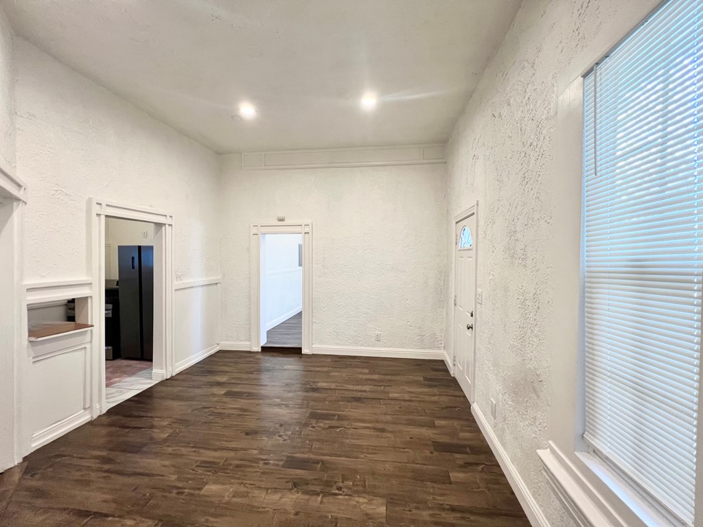 A room with wooden flooring and white walls.