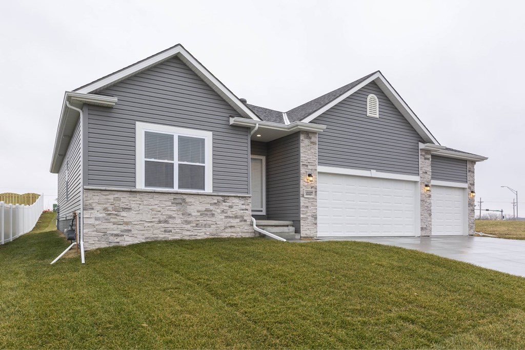 A house with a grey siding and a white garage door.