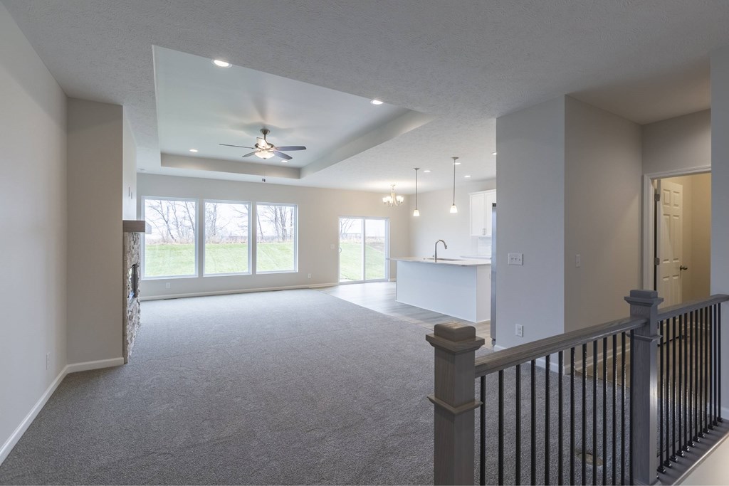 A spacious living room with a ceiling fan and sliding glass doors.