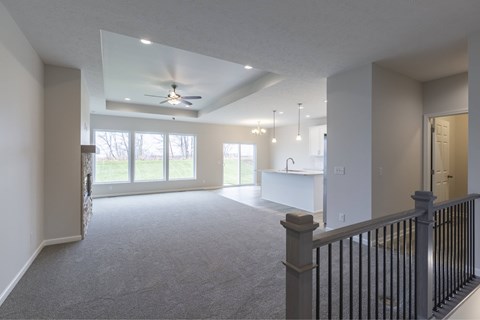 A spacious living room with a ceiling fan and sliding glass doors.