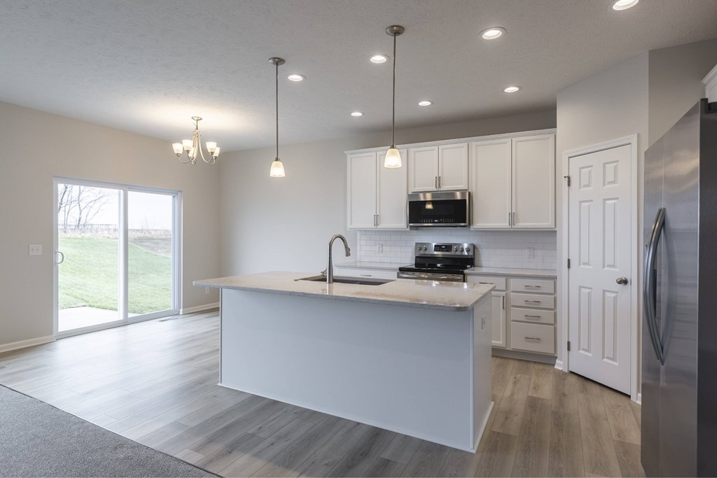 A modern kitchen with a large island and stainless steel appliances.